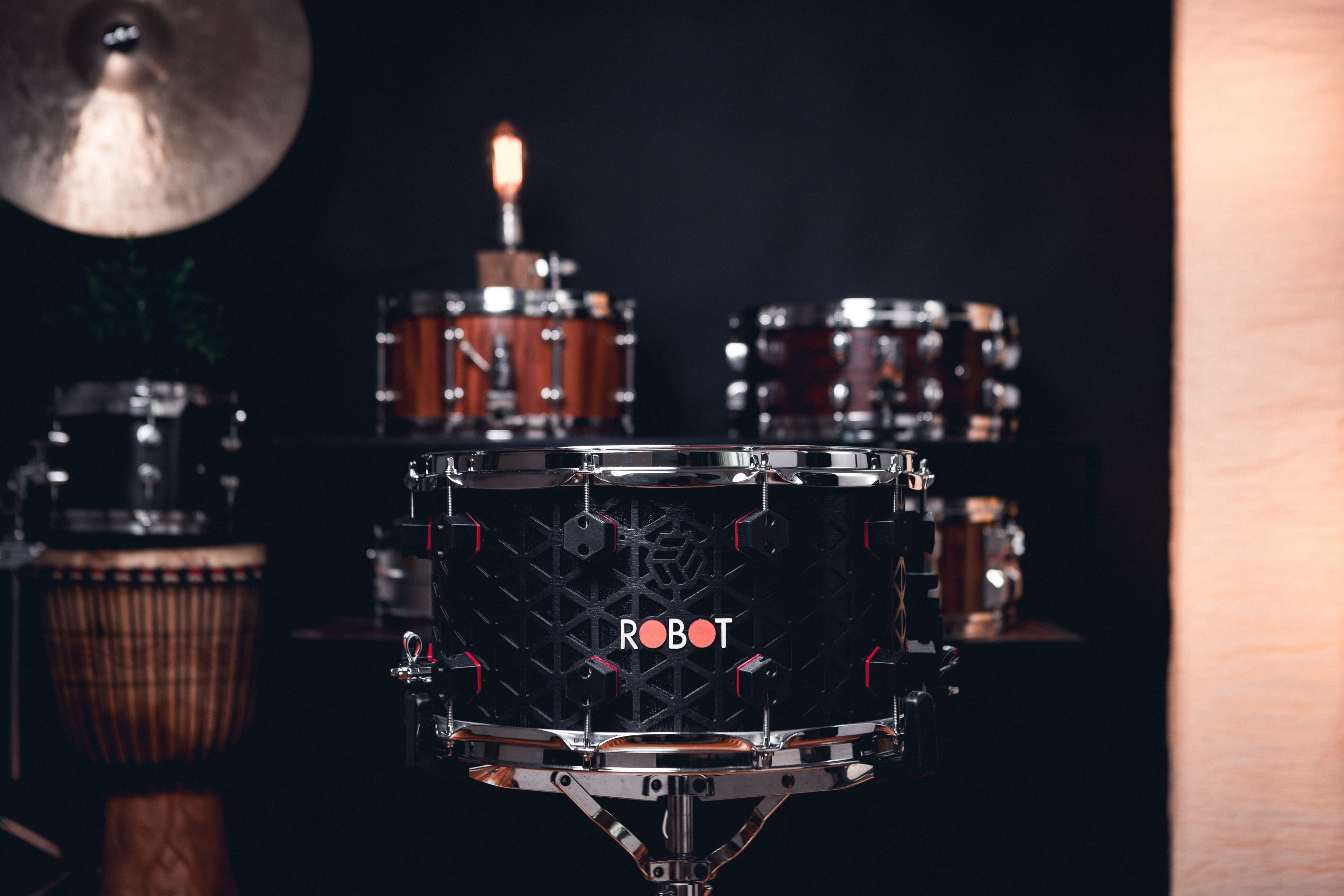 Black Robot snare with geometric shell machining and chrome hardware.